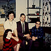 family sitting near Christmas tree